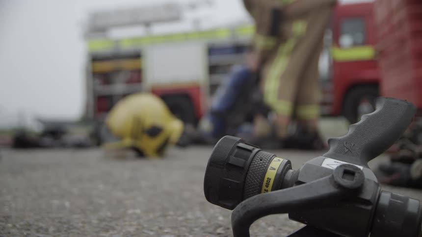 Firefighters work next to a firetruck