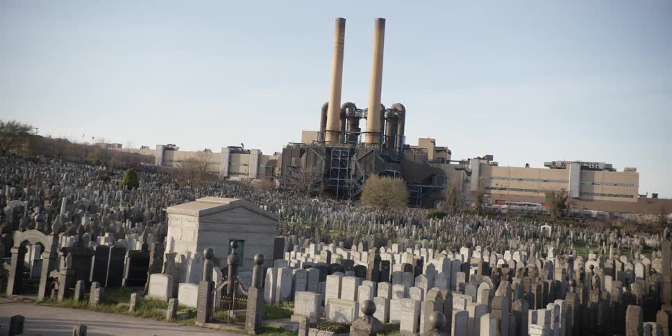 Aerial view of a crowded graveyard near an industrial building