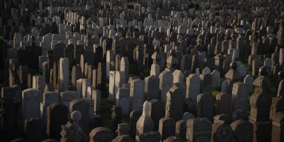 View of a cemetery at dusk with many tombstones all over