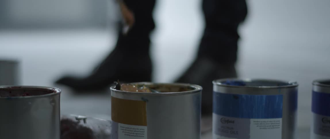 The person is mixing paint in the can