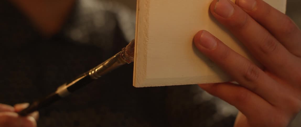 The person is painting with a brush