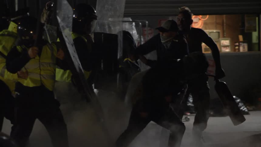 Rioters attack police with shields and batons