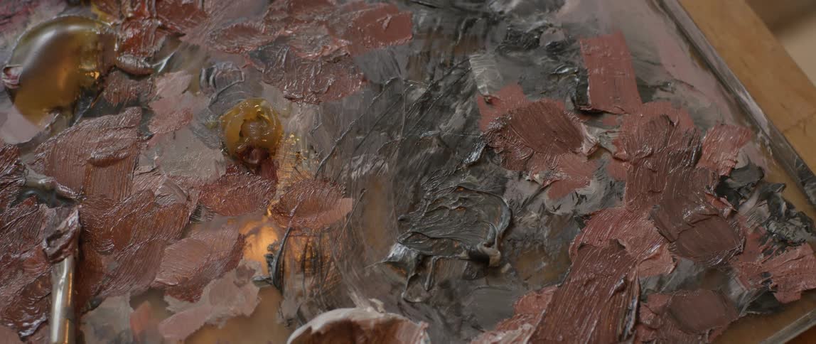 Smears of brown and black paint on a canvas