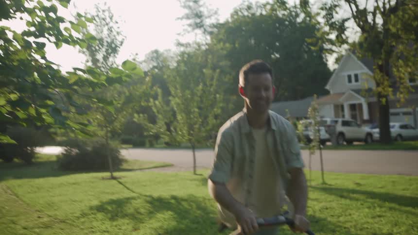 A man mows the front lawn