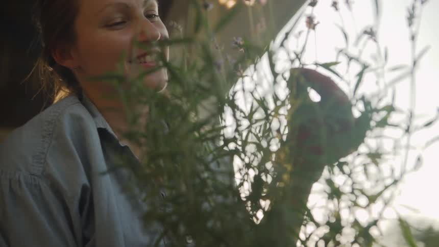 A woman smiles while gardening on a sunny day