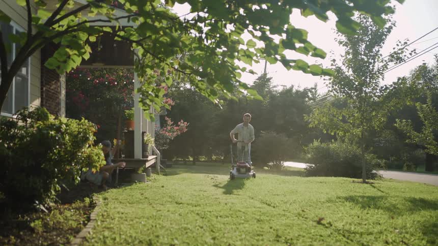 A man and woman do yard work in the front yard