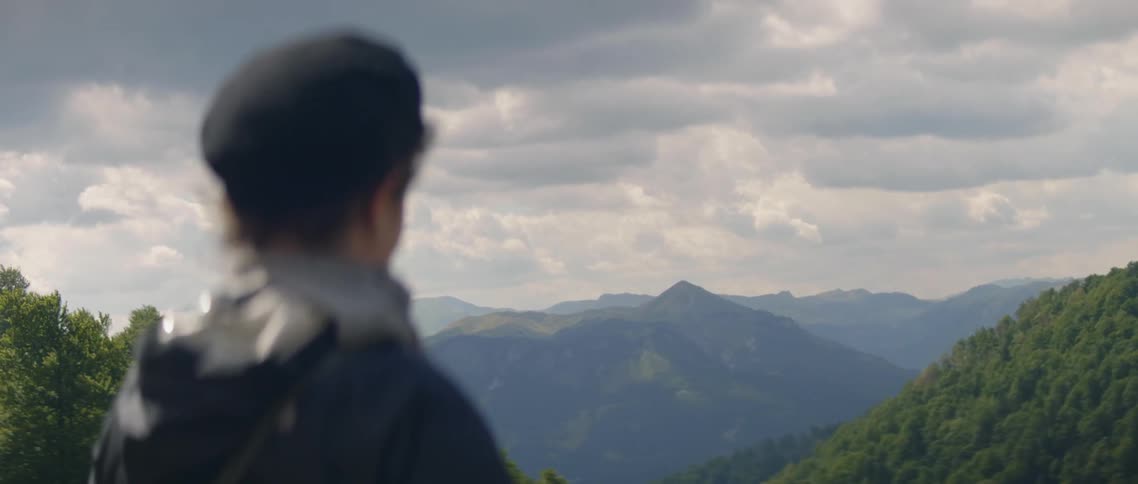 A Woman looks at the mountains in the distance