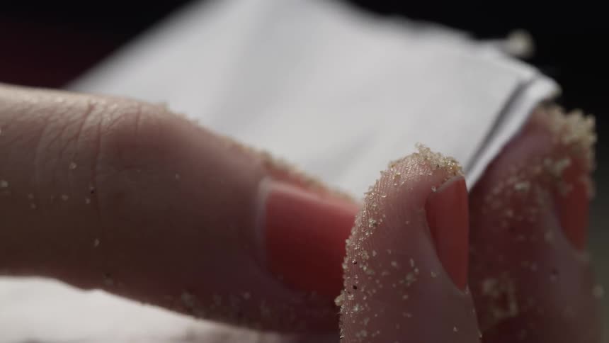 The person rubs the sand between their fingers