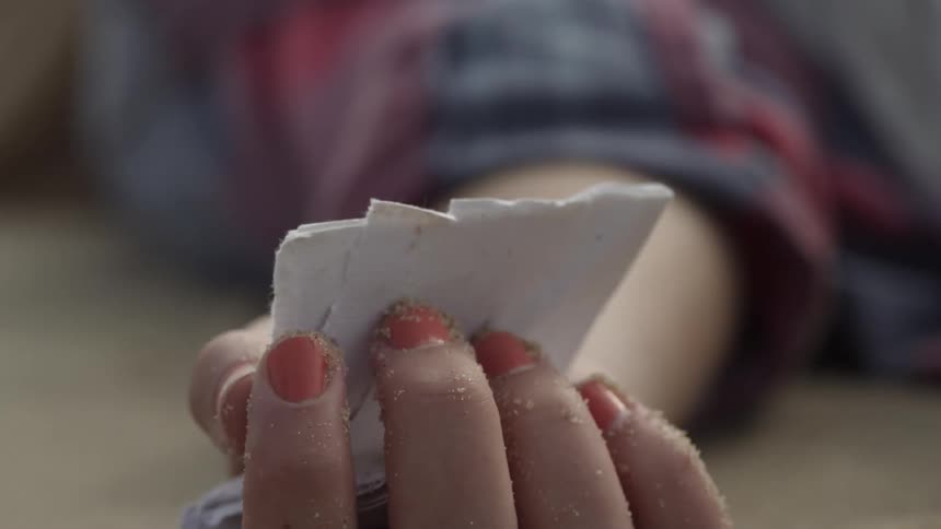 The person holds a paper in their hand