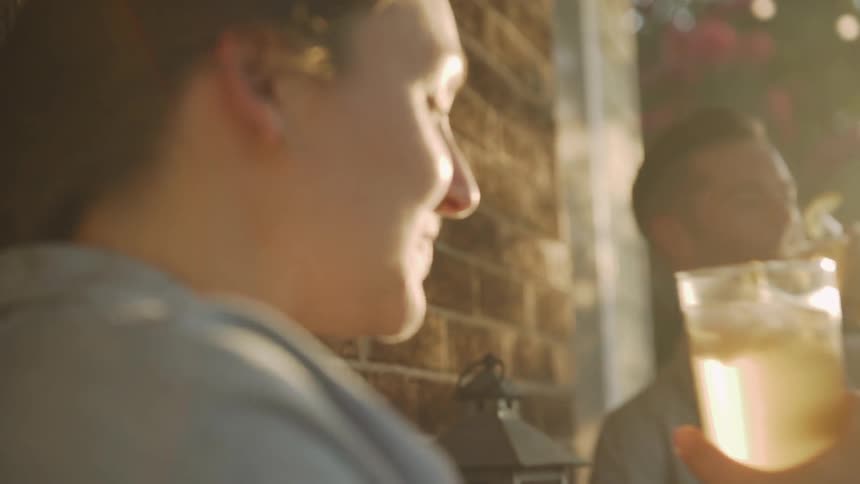 Young Couple Cheers with Iced Tea in Sunshine