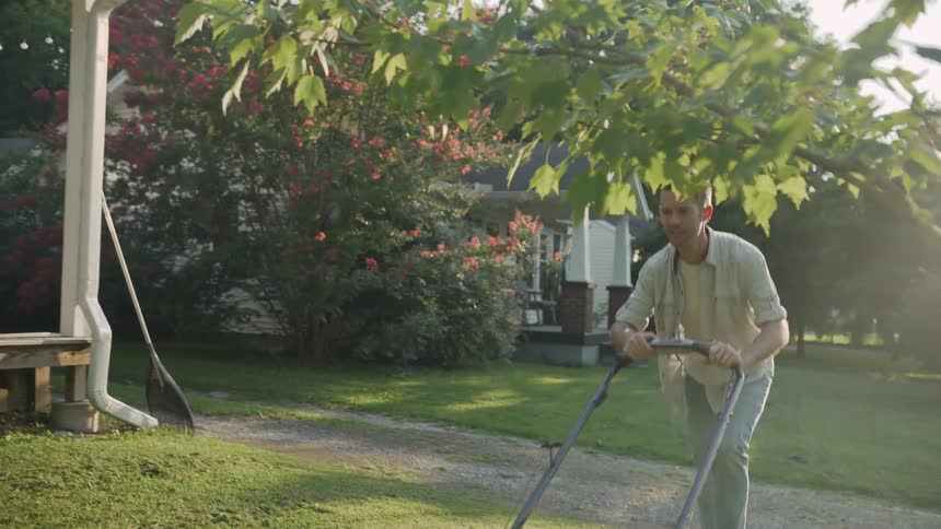 Man mows lawn on a sunny day