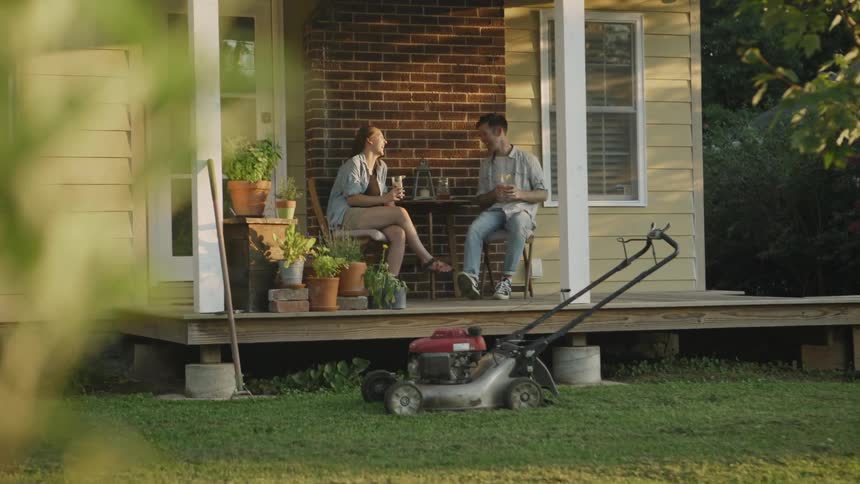 The two people have drinks on the porch