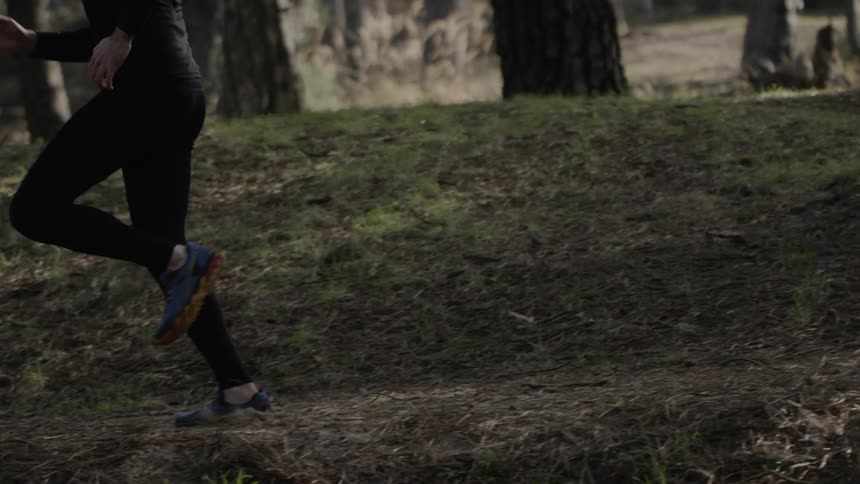 The person is racing through the forest