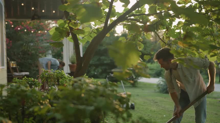 Man and woman do lawn work in the front yard
