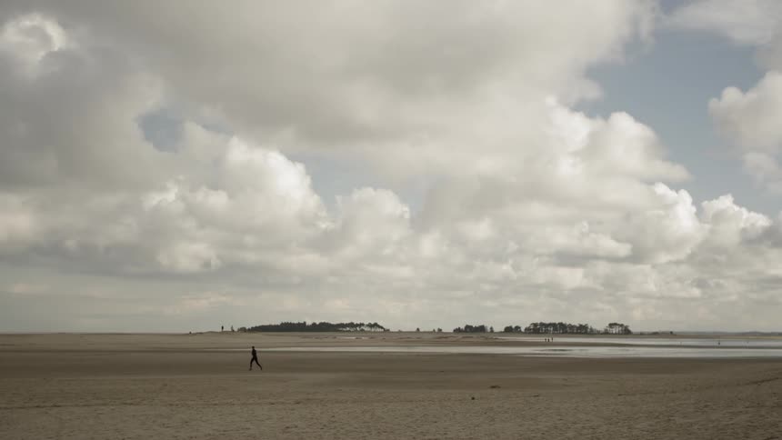 A man runs across the sand