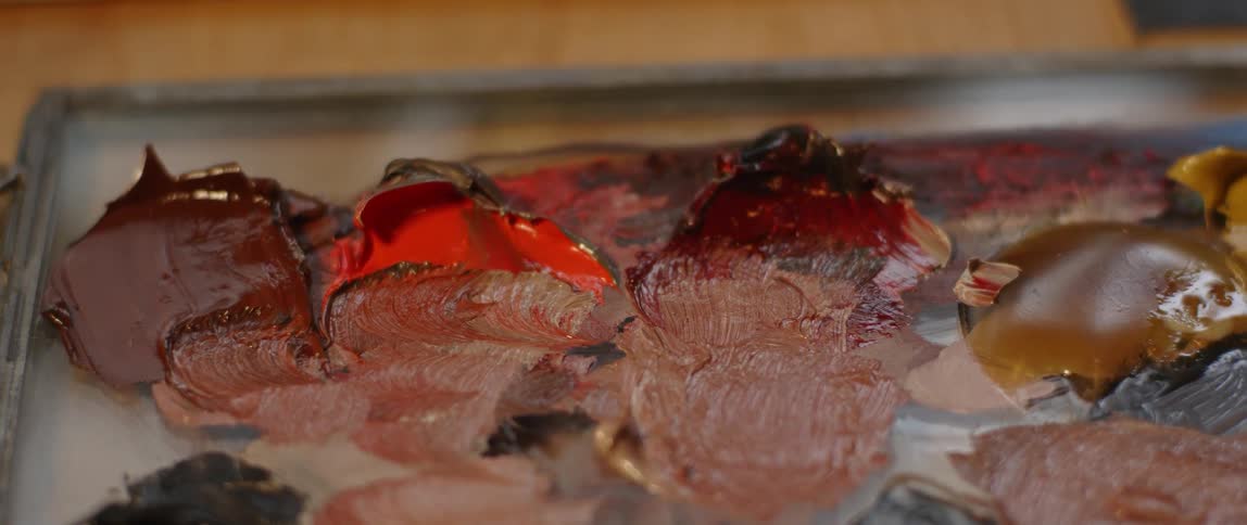 Smears of brown and orange paint on a table