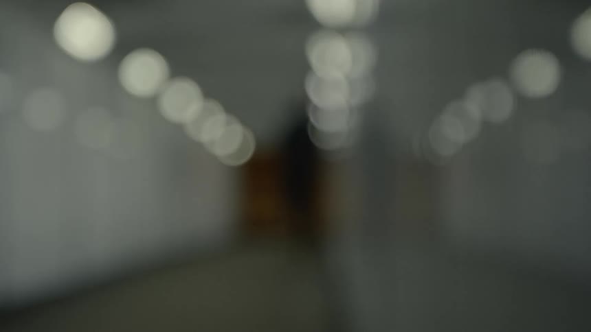 Person runs down a lit hallway in the evening
