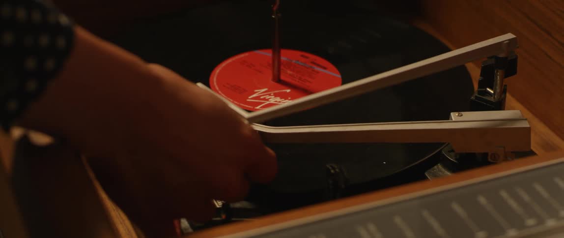 Person puts a needle on a record on a turntable