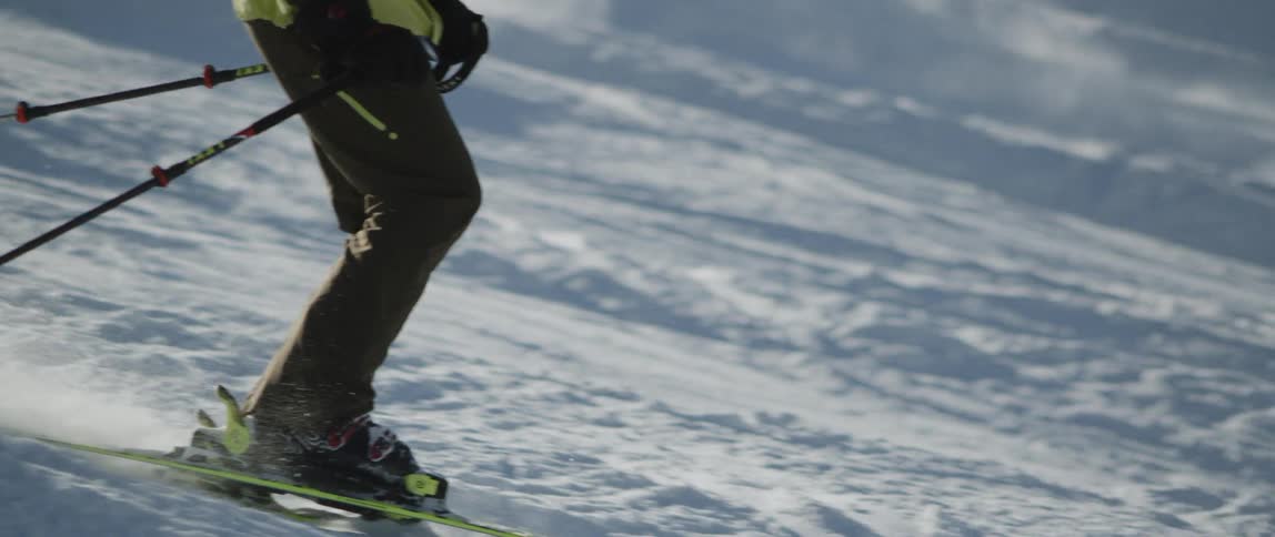 The people ski on the slope on a sunny day