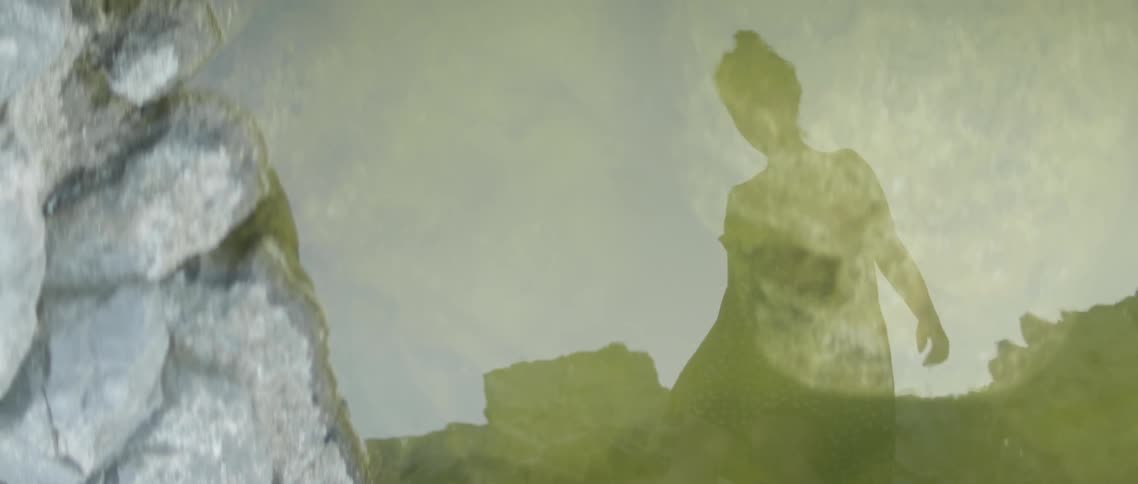 A woman is reflected in a puddle