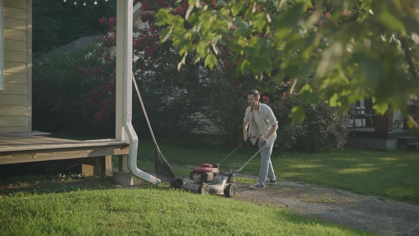 A man starts a lawn mower