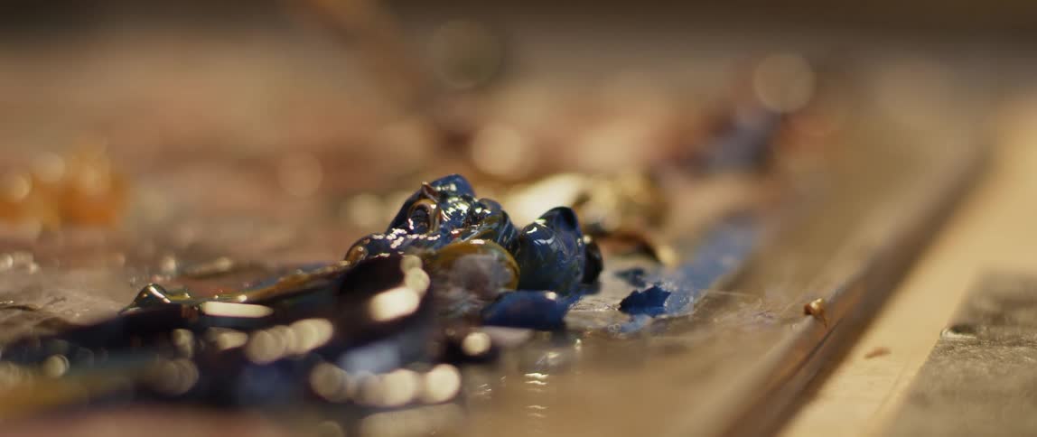 The person mixes paint on the table
