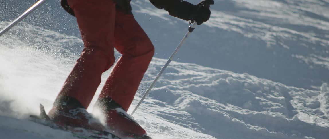 The person skis down the slope