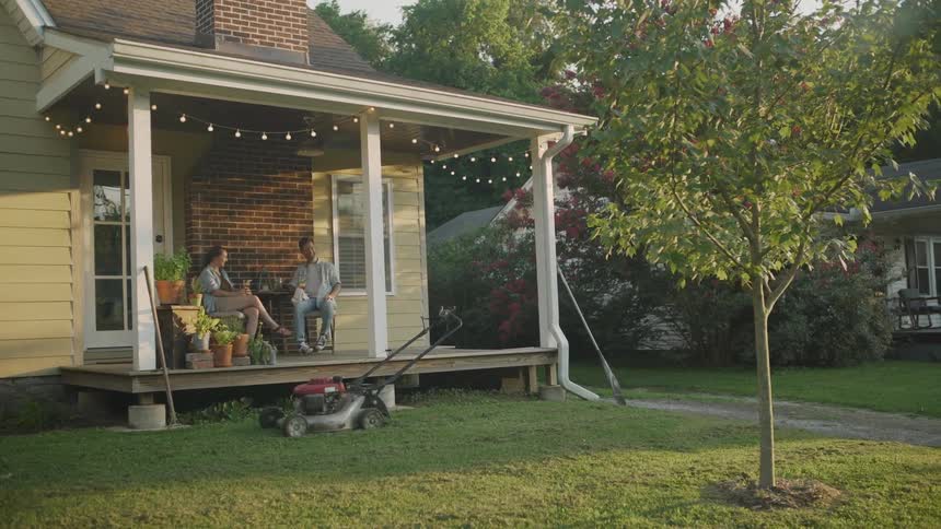 Couple Talking and Laughing on Their Porch After Yard Work