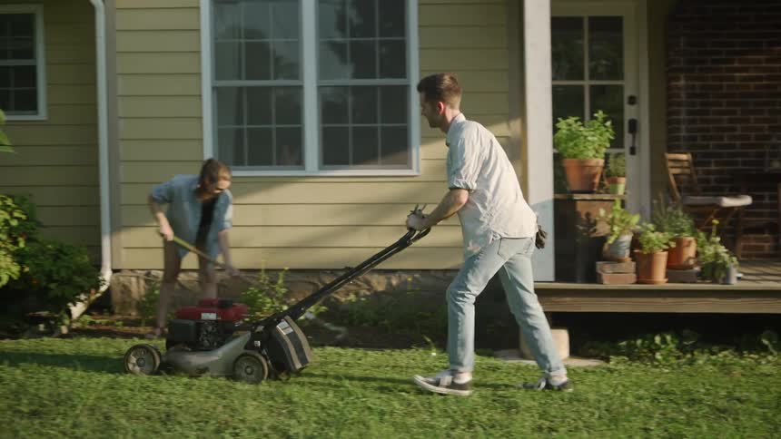 A man and woman do yard work on a summer day