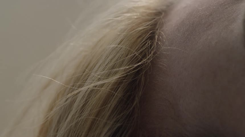 A breeze blows through a person's blond hair