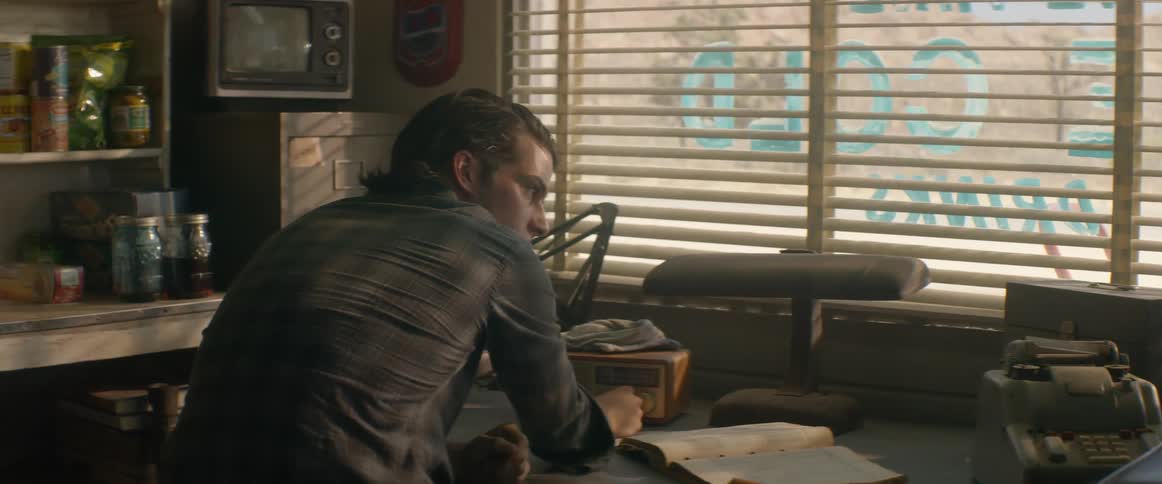 A man sits the counter of a business