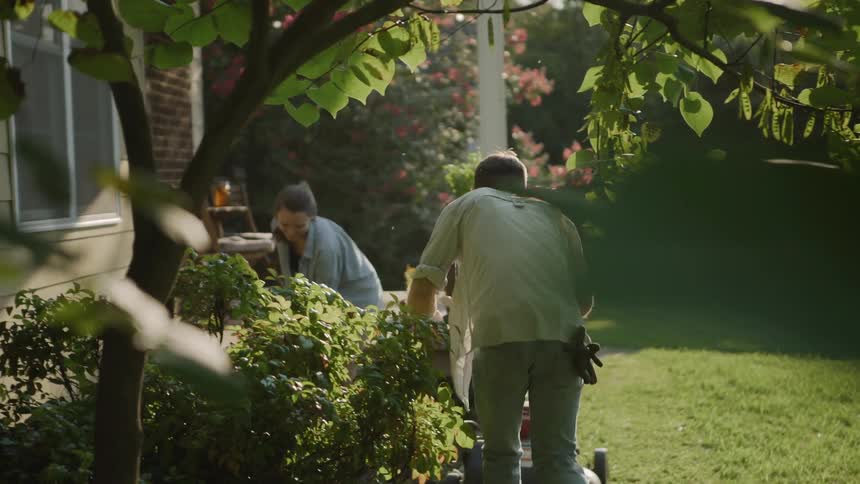 A man and woman do yard work on a summer day