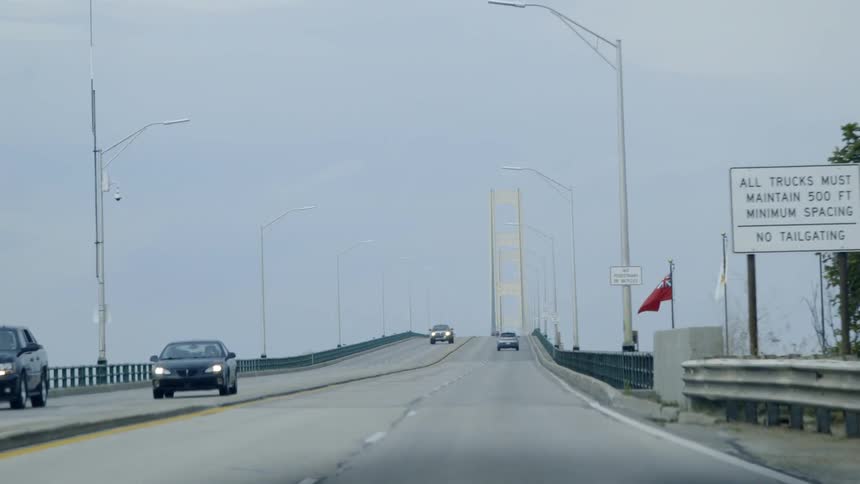 The vehicles travel towards the bridge