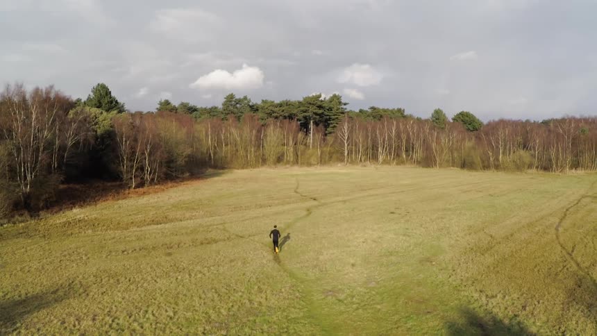 A man runs in the grassy field
