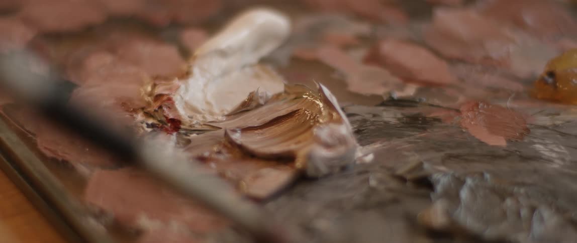 Artist's paintbrush spreads the paint on a painting