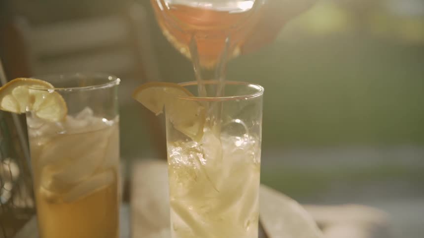 The person pours a beverage from the jar