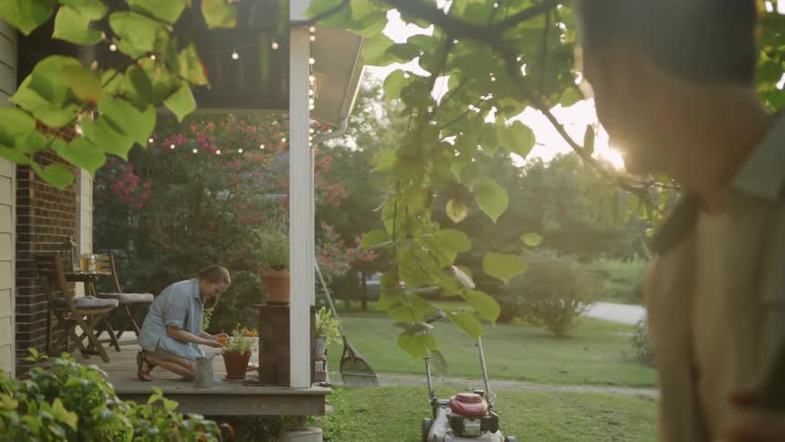 The man is working in the yard on a sunny day
