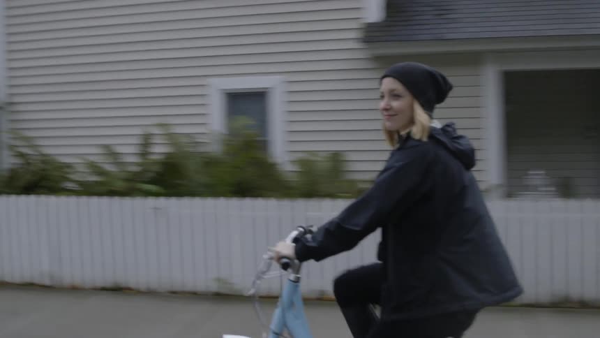 A woman bicycles on a residential street