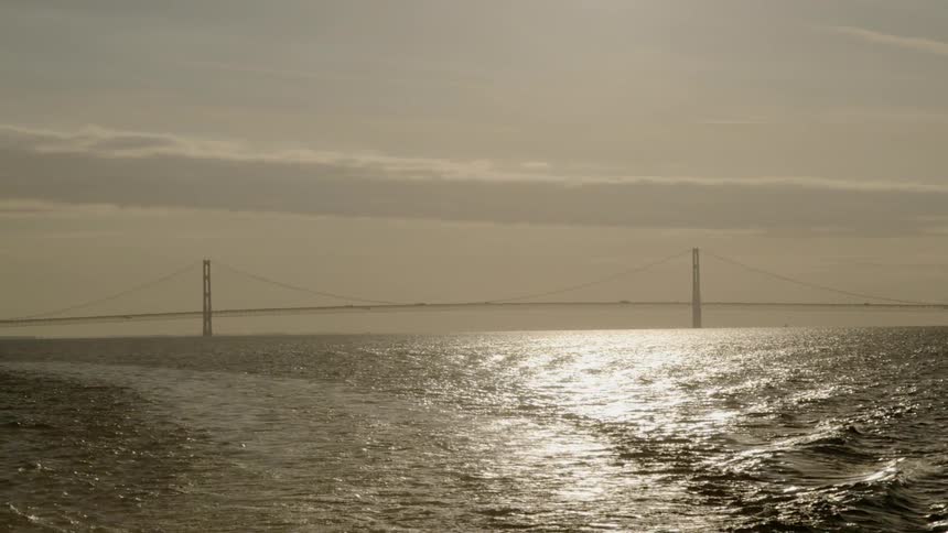 A boat floats near the golden gate bridge