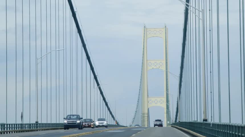 Cars drive over a large white bridge