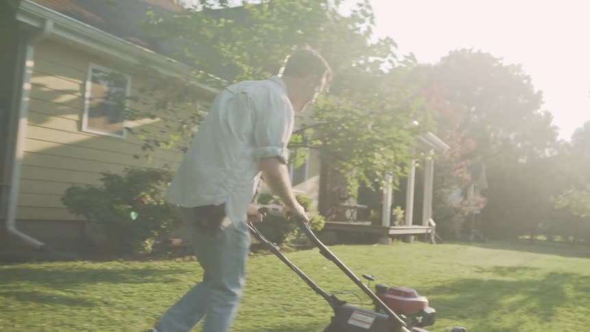 Man Mows Grass and Woman Uses Stirrup Hoe in Garden
