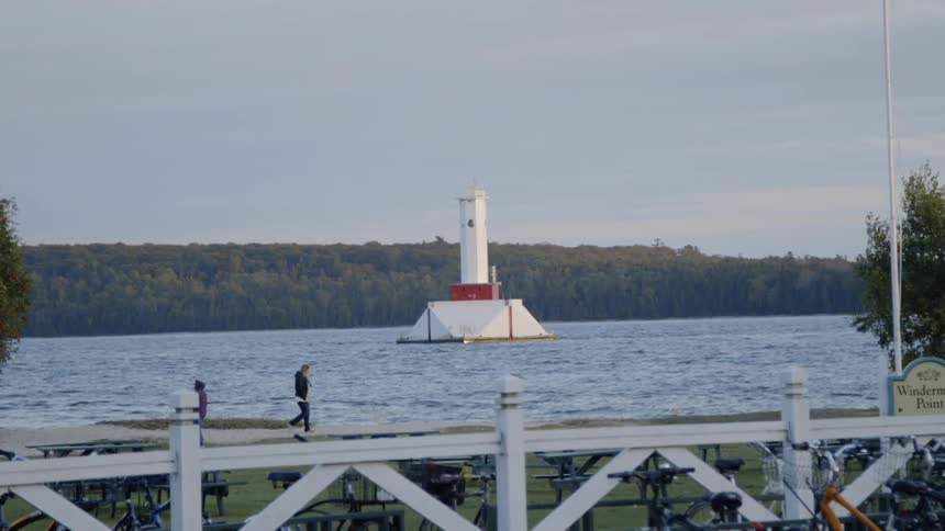 People walk next to a lake on a chilly day