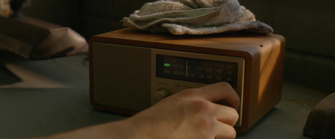 The person turns the knob off on the radio