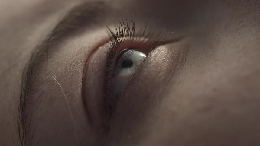 A woman opens and closes her eye