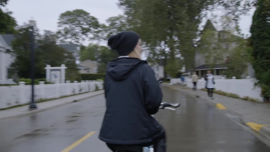 The woman rides around in the street on a bicycle