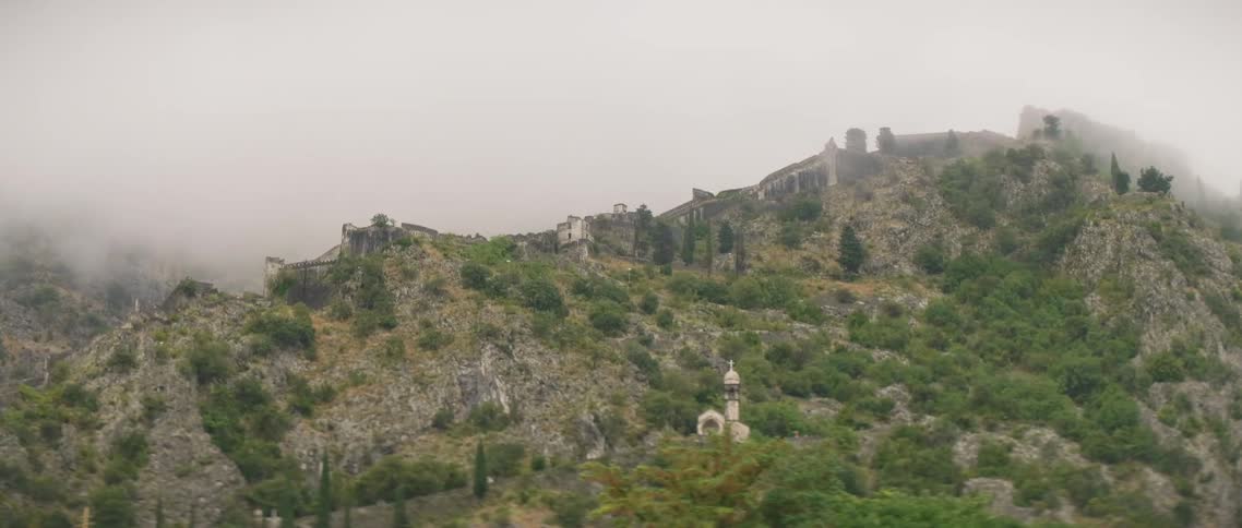 Buildings stand on a hillside on a cloudy day