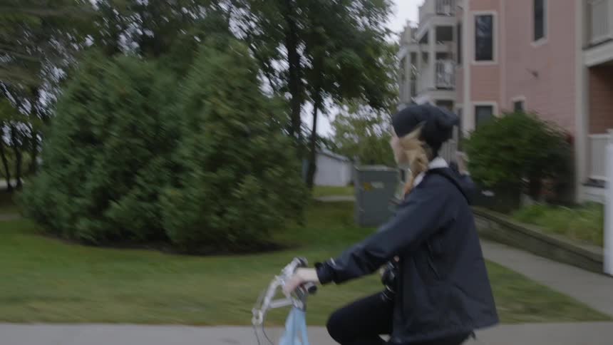 The woman rides her bicycle in the town