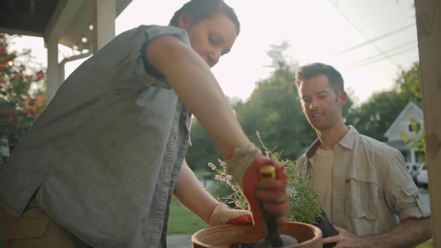 A woman is digging dirt in a pot