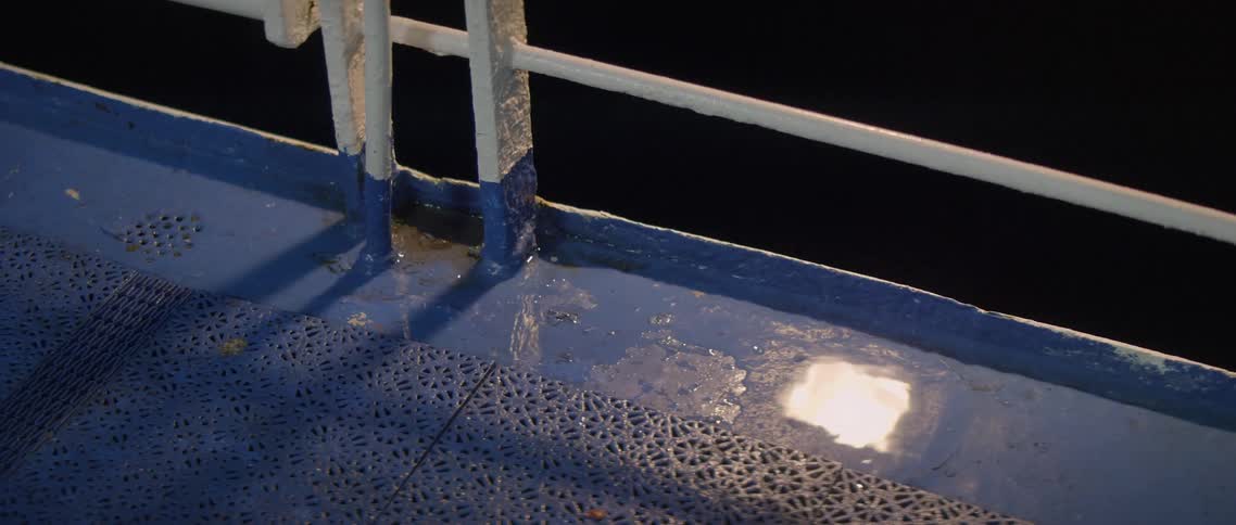 Light is reflected in a puddle on a boat deck