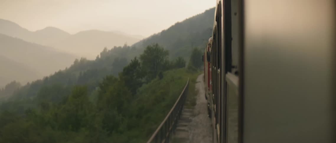 Train travels down the tracks in the mountains